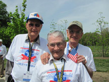 Three smiling veterans in matching shirts