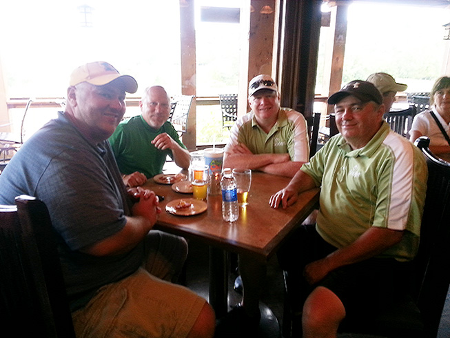 Four men sit at a table