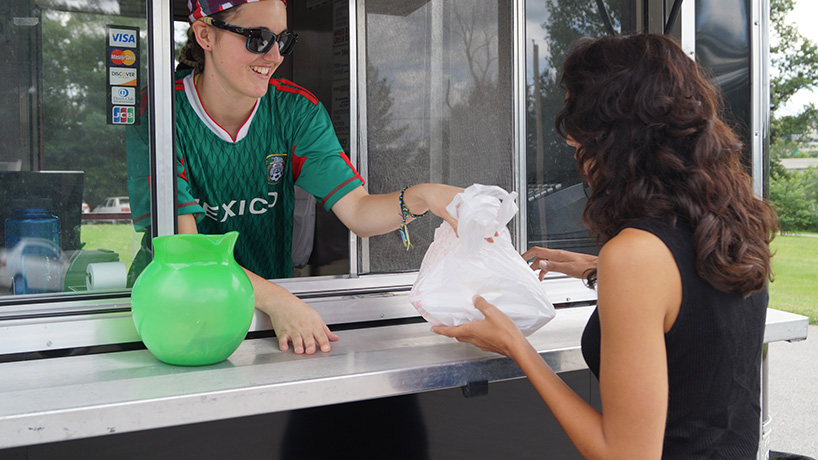 Pepes emloyee hands Socket employee bag of food from truck