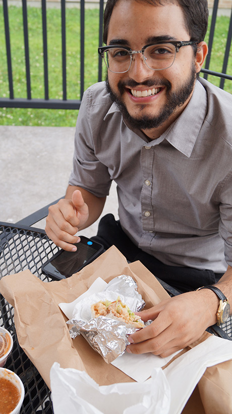 Smiling employee holds taco